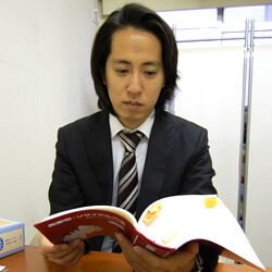 参考書籍を読む佐藤さん